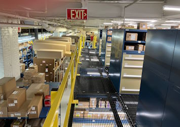 Mezzanine organized warehouse with cardboard boxes and storage shelves